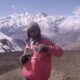 Posing with a pink jacket in front of snow clad mountain